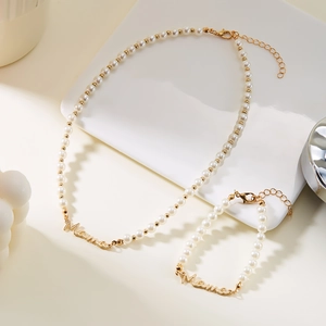 Vue détaillée de l'ensemble collier et bracelet Mama en or avec perles blanches