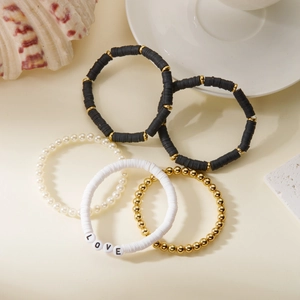 Detail eines 5-teiligen Armband-Sets mit LOVE-Buchstaben, Perlen und Heishi-Perlen