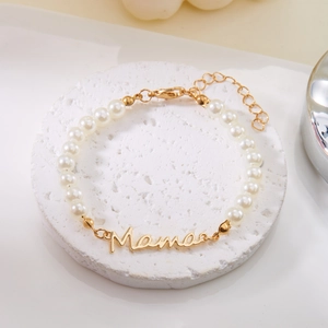 Détail du bracelet de perles élégant avec charm Mama doré et fermoir mousqueton ajustable