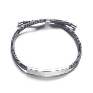 Gros plan d'un bracelet câble gris réglable avec une barre en acier inoxydable poli