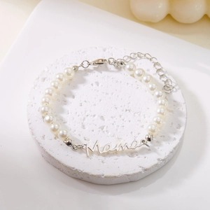 Détail d'un bracelet en perles avec breloque Mama en argent et fermoir mousqueton