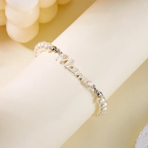 Détail du bracelet en perles Mama avec perles blanches et lettrage en métal argent