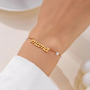 Détail du bracelet perles MAMA doré porté au poignet avec lettrage cursif élégant
