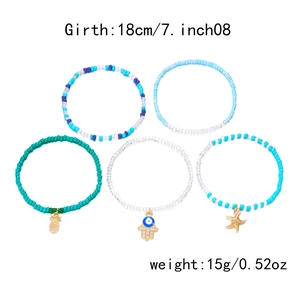 Detail view of 5-piece bohemian bead bracelet set with pineapple and evil eye charms