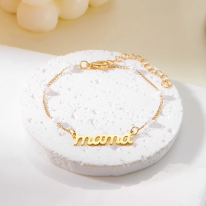 Détail du collier MAMA doré avec perles blanches élégantes et lettres en cursive