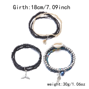 Detail of 3-piece bohemian beaded bracelets with sea shell and whale tail pendants