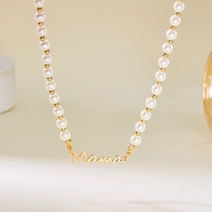 Détail du collier Mama doré avec perles blanches et accents de petites perles d'or