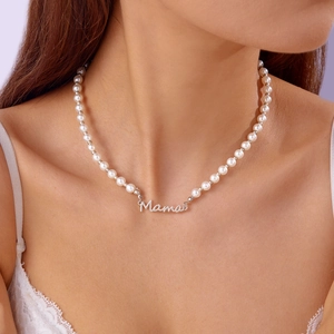 Gros plan d'un collier de perles d'eau douce avec pendentif lettre Mama en argent