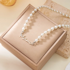 Vue détaillée du collier en perles Mama avec pendentif argenté sur un coffret cadeau
