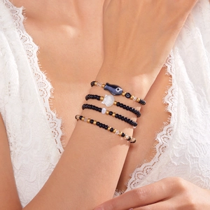 Detalle del conjunto de pulseras bohemias con dijes de pez azul y concha marina