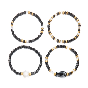 Detalle del set de pulseras boho con cuentas, pez de cerámica y conchas de mar