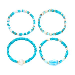 Primer plano del set de pulseras bohemias con concha, pez de cerámica y cuentas turquesas