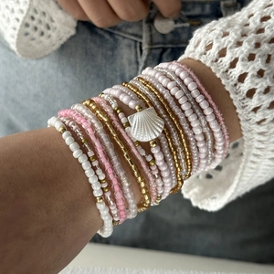 Λεπτομέρεια από boho πολυεπίπεδο σετ βραχιόλια με χάντρες και λευκό μενταγιόν κοχύλι