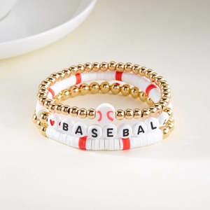 Detailset van drie baseball-armbanden met rode en witte kleikralen en gouden bolletjes