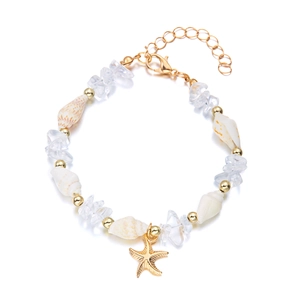 Detailansicht eines goldenen Seestern-Armbands mit weißen Muscheln und klaren Steinen