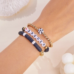 Detailweergave van een 3-delige voetbalarmbandset met gouden kralen en 'SOCCER' letterkralen
