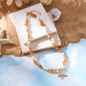 Detail der Strandkette mit Seestern-Anhänger, orangefarbenen Steinen und weißen Muscheln