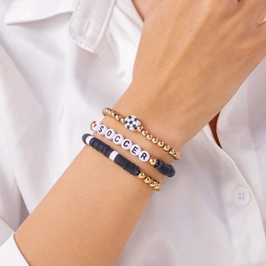 Detailopname van een driedelige voetbal kralenarmbandenset met het woord SOCCER