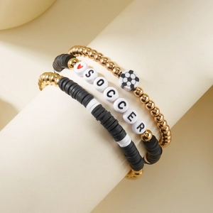 Detailopname van driedelige voetbalarmbandset met polymeerklei kralen en bedeltjes