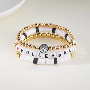 Detail van een driedelige volleybal armbandset met gouden kralen en kleischijven