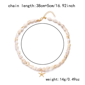Detail of natural white spiral shells necklace with a gold starfish pendant and lobster clasp