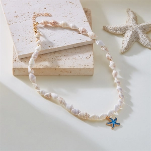 Detail of seashell necklace featuring a blue starfish pendant on a white stone background