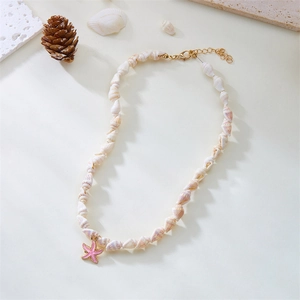 Detail of seashell necklace with pink starfish pendant and gold lobster clasp closure