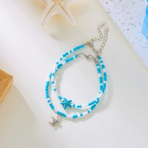 Detail eines blauen Seestern-Anhängers an einem zweilagigen Perlen-Fußkettchen für Strand