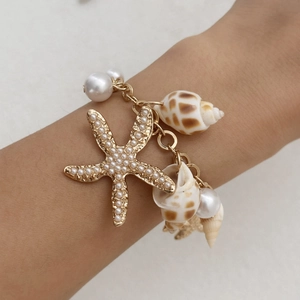 Detail of bohemian gold waist chain with seashell pendants and pearl starfish charms
