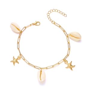 Detail von Strandschmuck mit goldenen Seesternen und weißen Muschel-Anhängern an einer Kette