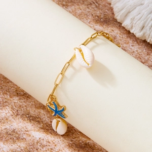 Detail der goldenen Gliederkette mit blauem Seestern und natürlichen Muschelanhängern