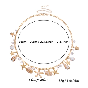Detailed view of bohemian gold waist chain with seashell and starfish charms on white background