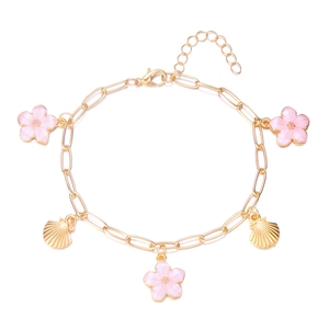 Detail eines Boho-Fußkettchens mit rosa Kirschblüten und goldenen Muschel-Anhängern