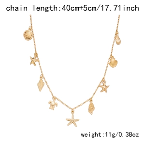 Detail view of gold ocean charms necklace featuring starfish shell and sea turtle pendants
