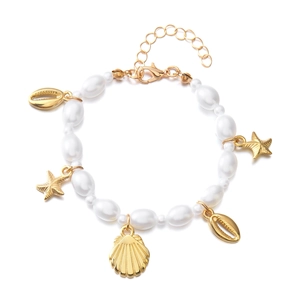 Detailed view of ocean-themed pearl bracelet with golden starfish and seashell charms