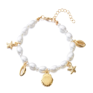 Detail of beach-style pearl necklace featuring golden starfish and seashell charms