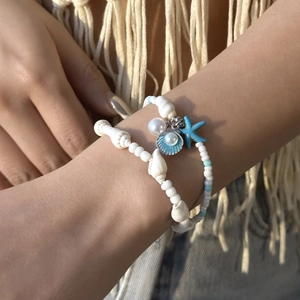 Nahaufnahme von zweilagigen Perlenarmbändern mit blauem Seestern und Muschelanhängern