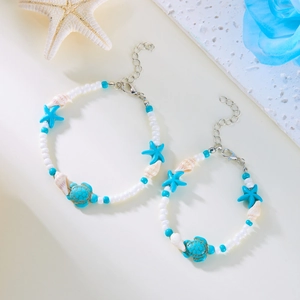 Detail eines Strand-Fußkettchen-Sets mit Türkis-Schildkröte, Seestern und Muscheln