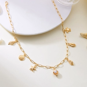 Detail of gold chunky chain necklace featuring starfish, turtle, and shell charms with pearl