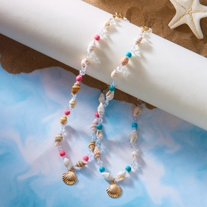 Detail der Sommer-Muschelperlenkette mit rosa türkisen Perlen und goldenem Muschel-Anhänger