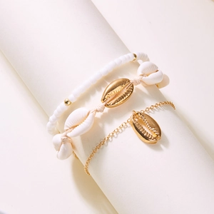 Detail of bohemian beach anklet set featuring natural sea shells and gold charms
