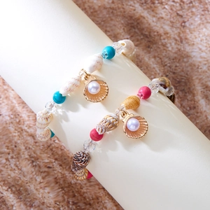 Detail von böhmischen Muschelperlen-Armbändern mit türkisfarbenen Perlen und Goldanhänger