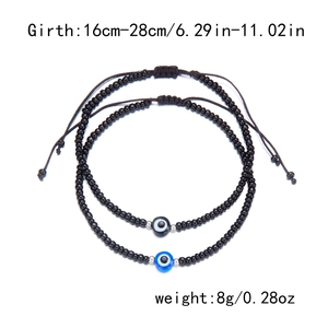 Detail of adjustable black evil eye beaded bracelet set with woven drawstring closure