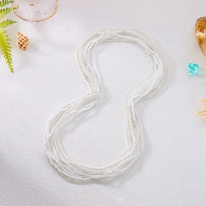 Detail of multi-layer white seed beads and silver chain beach waist jewelry set