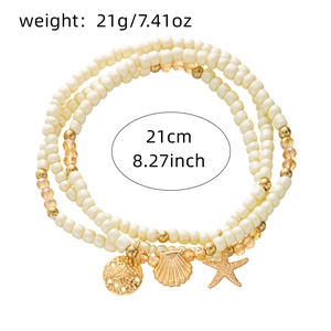 Detail of bohemian starfish shell anklet set featuring cream beads and golden pendants