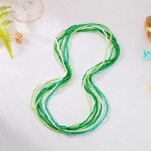 Detail of multi-layered green and white beaded waist chains with seashells and starfish decor