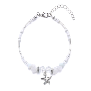 Detail van witte kralenketting met kristalstenen en een zilveren zeester hanger