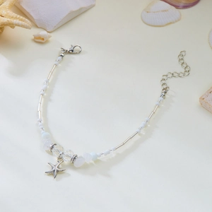 Detail van de zeester ketting met witte kralen en een zilveren karabijnsluiting