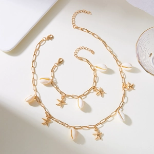 Nahaufnahme der goldenen Büroklammer-Kette und Armband mit Seestern und Muscheln