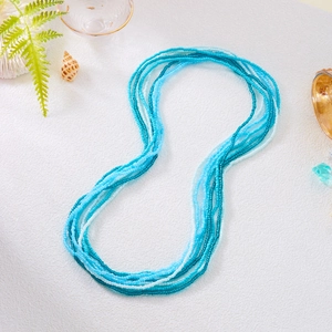 Detail of bohemian multilayer blue bead waist chains with sea shells on white surface